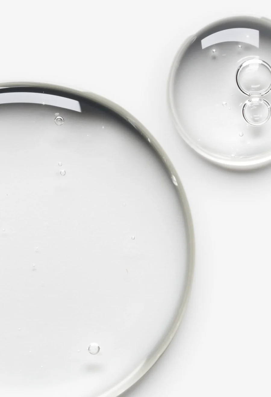 Gotas transparentes de ativo líquido sobre fundo branco
